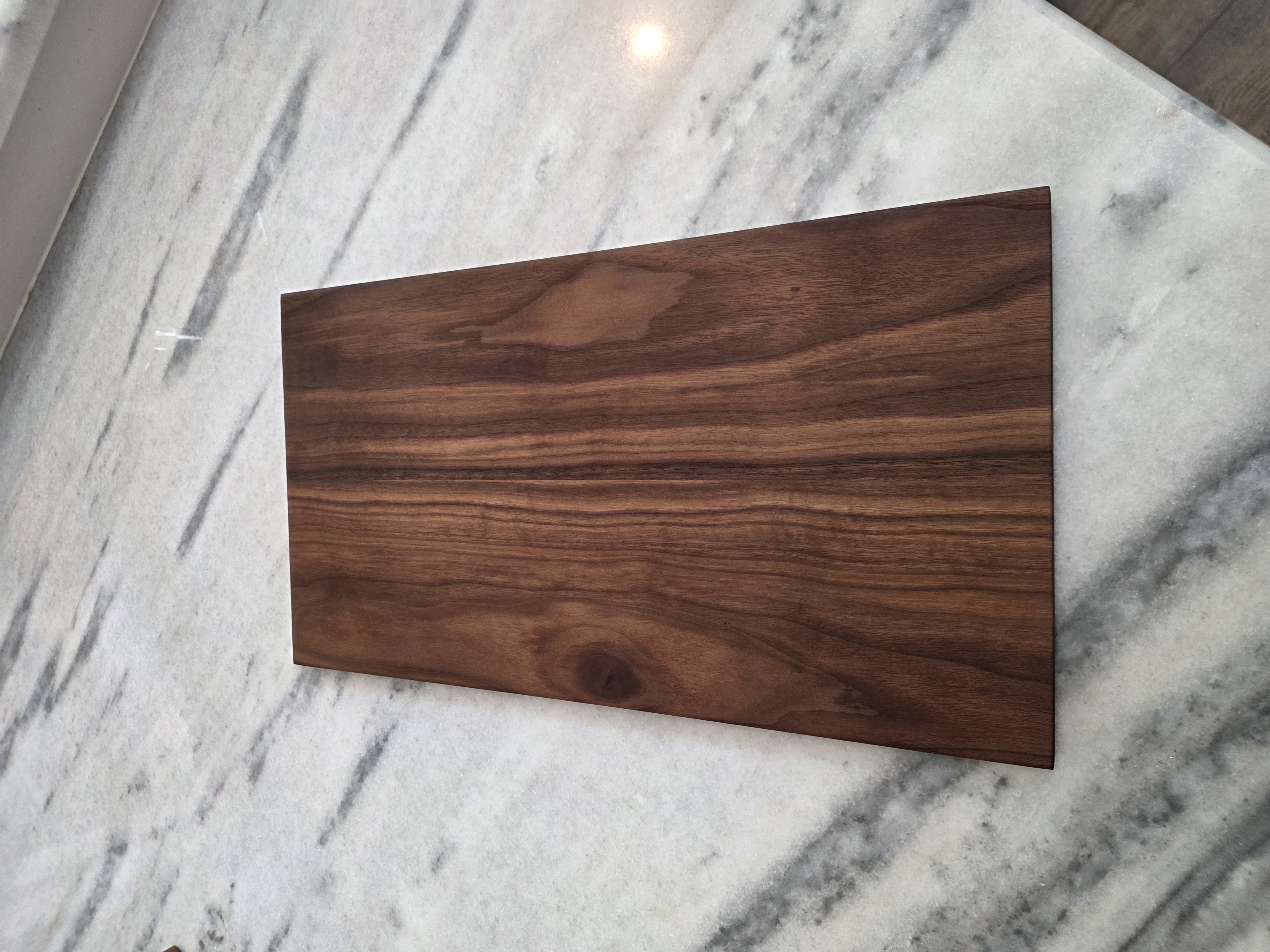 Solid American Black Walnut Cathedral Grain Charcuterie and Bread Board on Marble Countertop